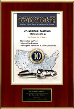 A plaque displaying Castle Connolly Top Doctors with an outline of the United States and a stethoscope. It reads Dr. Michael Gartlan, Otolaryngology, Top Doctor for 10 Years. A circular emblem notes the 10-year achievement.